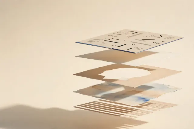 AI-generert illustrasjon: Et trykket plakatark delt i adskilte papirlag – motiv, bakgrunn og dekorasjon – som svever med synlige mellomrom over et kremfarget studiounderlag.