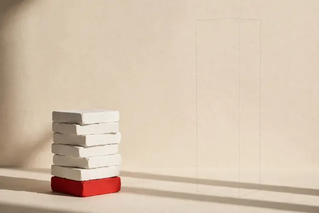 Illustration: two towers of white blocks, one clearly shorter than an outlined expectation — a visual metaphor for OpenAI's revenue falling below the assumed level.