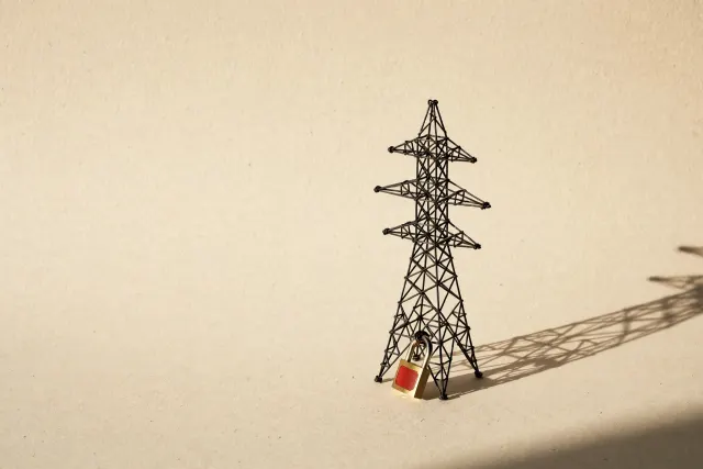 Illustration: a miniature wire electricity pylon on paper, secured by a single brass padlock hanging open – a metaphor for weak password protection of critical infrastructure.