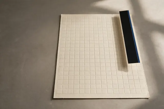 A paper grid sheet with a narrow black side panel strip lifted along its right edge – an illustration of an AI side panel integrated into documents and spreadsheets.
