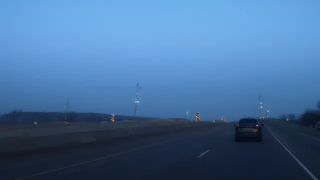 En bil kjører på en stille amerikansk motorvei i skumringen.