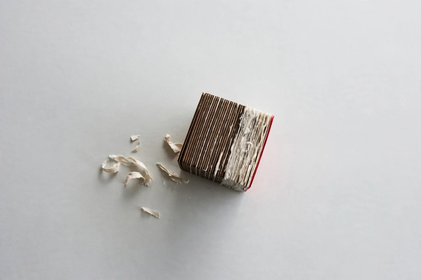 Illustration: A small, dense cube of layered wood and paper sits alone on a vast empty table, evoking a lightweight open model anyone can pick up and use.