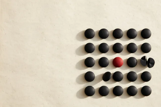 Illustration: a precise grid of black counting stones on paper, with a few stones sitting ambiguously between cells – a metaphor for disputed figures in a mathematics release.