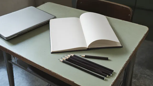 Illustration: a school desk with a closed laptop, an empty notebook, and one worn-down pencil beside a row of untouched new pencils.