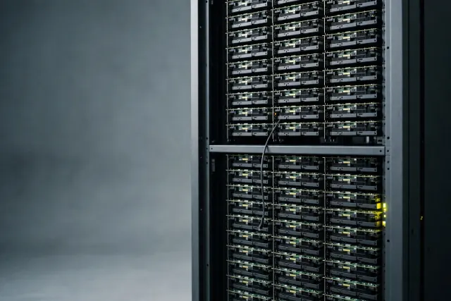 Illustration: an open cabinet resembling a server rack with rows of exposed GPU modules and a loose monitoring cable, a metaphor for unauthenticated hardware left visible.