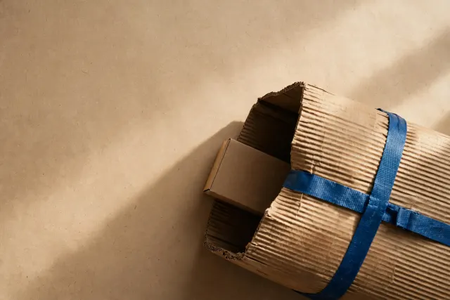 Illustration: a small cardboard box sliding into a much larger one, evoking an acquisition in which a smaller company is absorbed by a bigger one.