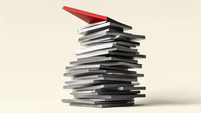 Illustration: a tall, precariously tilted tower of blank metal plates, the top one red and about to tip – an image of a stock listing with an enormous valuation and high risk.