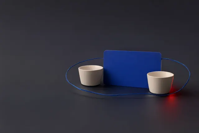 Illustrasjon: To kaffekopper og et blankt blått betalingskort er koblet sammen av en tynn blå linje.