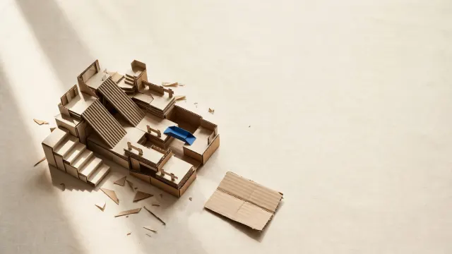 Illustrasjon: en detaljert miniatyrdigital bane laget av foldet papp og papir, der én seksjon er uferdig og klippet midt i en brettekant.