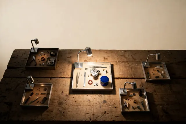 Illustration: a large workbench holding several small self-contained workstations, one lit brightly while the others sit dimly in shadow.