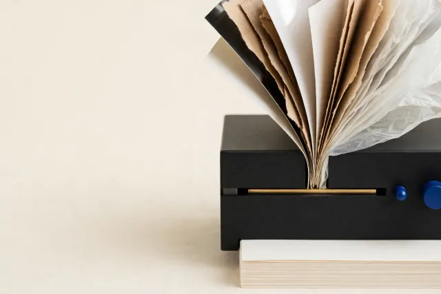 Illustration: different kinds of paper fed through a single slot in a machine block emerging as one uniform stack, a metaphor for ten document models behind one API.