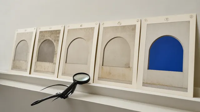 Illustration: Five prints of the same arch shape pinned in a row on a studio wall, the earliest prints crooked and incomplete, the last one crisp and whole. A magnifying loupe on the sill points back toward the row.
